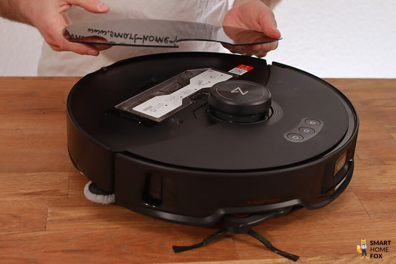 Die dünne Klappe des Roborock S8 MAxV Ultra wir din den Händen gehalten.